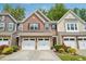 Charming townhome with brick facade, two-car garage, and manicured landscaping at 409 Summit Trail Dr, Hillsborough, NC 27278
