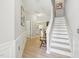 Inviting foyer with wood flooring, staircase, and views into the kitchen and living areas at 409 Summit Trail Dr, Hillsborough, NC 27278