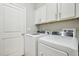 Functional laundry room with white cabinets, modern washer and dryer, and ample storage space at 409 Summit Trail Dr, Hillsborough, NC 27278