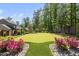 Beautiful backyard putting green surrounded by colorful flowers and professional landscaping at 4139 Rockingham Dr, Raleigh, NC 27609