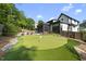 Professionally landscaped backyard featuring a putting green with stunning landscaping and modern home design at 4139 Rockingham Dr, Raleigh, NC 27609