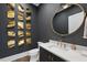 Stylish powder room with unique modern art and a gold-framed mirror at 4139 Rockingham Dr, Raleigh, NC 27609