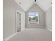 Bright bedroom featuring a vaulted ceiling, large window, and neutral carpet at 4139 Rockingham Dr, Raleigh, NC 27609