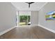 Bright, airy bedroom with hardwood floors, a ceiling fan, and large windows offering scenic backyard views at 4139 Rockingham Dr, Raleigh, NC 27609