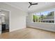 Sunlit bedroom with beautiful hardwood floors, a ceiling fan, and a window view of the landscape at 4139 Rockingham Dr, Raleigh, NC 27609