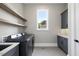 Well-organized laundry room with modern appliances, floating shelves, and ample counter space at 4139 Rockingham Dr, Raleigh, NC 27609