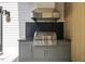 Well-equipped outdoor kitchen featuring stainless steel grill and hood, perfect for entertaining at 4139 Rockingham Dr, Raleigh, NC 27609