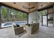 Covered outdoor living space with fireplace, ceiling fan, and comfortable seating near a modern pool and landscaped yard at 4139 Rockingham Dr, Raleigh, NC 27609