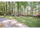 Tranquil backyard space surrounded by mature trees and colorful azalea bushes, perfect for relaxation at 449 Hill Rd, Franklinton, NC 27525