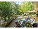 Cozy backyard deck with comfortable seating and overhead string lights, surrounded by lush greenery for tranquil outdoor enjoyment at 449 Hill Rd, Franklinton, NC 27525