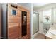 Bright bathroom featuring a wood sauna, glass door shower, and natural light from the window with floral accents at 449 Hill Rd, Franklinton, NC 27525