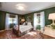 Bedroom with a four poster bed, wooden window blinds, area rug, and green walls at 449 Hill Rd, Franklinton, NC 27525