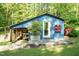 Quaint blue building showcasing a covered area with work space, garden decor, and an outdoor patio at 449 Hill Rd, Franklinton, NC 27525