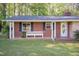 Charming brick home with black shutters and a cozy front porch and bench at 449 Hill Rd, Franklinton, NC 27525