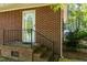 Brick home entrance with steps, black railing, and a partially covered porch at 449 Hill Rd, Franklinton, NC 27525