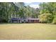Inviting brick home with a large, verdant front yard surrounded by lush, mature trees at 449 Hill Rd, Franklinton, NC 27525