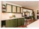 Traditional kitchen with custom green cabinetry, woven upper cabinet inlays, and views to the living area at 449 Hill Rd, Franklinton, NC 27525