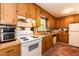This kitchen showcases wooden cabinets, a white range, and ample counter space, with a rug adding warmth at 449 Hill Rd, Franklinton, NC 27525