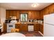Traditional kitchen featuring wood cabinets, a window over the sink, and a white refrigerator at 449 Hill Rd, Franklinton, NC 27525