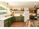 This well appointed kitchen boasts green cabinets, open shelving, and ample natural light at 449 Hill Rd, Franklinton, NC 27525
