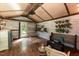 Quaint living room featuring hardwood floors, wicker furniture, and rustic wood-paneled walls and ceiling at 449 Hill Rd, Franklinton, NC 27525