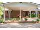 Covered patio featuring a dining table, porch swing, brick accents, and access to the yard at 449 Hill Rd, Franklinton, NC 27525
