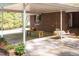 Spacious covered patio with a dining table, porch swing, and access to a lush green yard at 449 Hill Rd, Franklinton, NC 27525