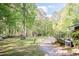 Lush green lawn bordered by mature trees, driveway, shed, and an external AC unit at 449 Hill Rd, Franklinton, NC 27525