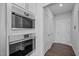 Built-in stainless steel microwave and oven in the kitchen with white cabinets and hardware at 450 Shale Creek Dr, Durham, NC 27703