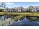 A tranquil view of the neighborhood pond with surrounding homes in the background at 450 Shale Creek Dr, Durham, NC 27703