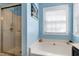Bathroom with a large soaking tub, separate glass-enclosed shower, and lots of natural light at 4793 Overhills Rd, Spring Lake, NC 28390