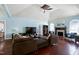 Bright living room with high ceilings, fireplace, dark sofa, and hardwood floors offers a comfortable space at 4793 Overhills Rd, Spring Lake, NC 28390