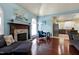 Open-concept living room with fireplace, hardwood floors, view to the kitchen and dining areas, and modern lighting at 4793 Overhills Rd, Spring Lake, NC 28390