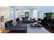 Spacious living room with large windows, dark sofa, hardwood floors, and a modern open-concept design at 4793 Overhills Rd, Spring Lake, NC 28390