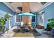 Outdoor patio featuring a table and chairs, umbrella, brick chimney and blue siding at 4793 Overhills Rd, Spring Lake, NC 28390