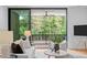 Living room showcasing a sofa with plush pillows and views of the outdoor deck with a wooded backdrop at 501 S Bloodworth St # 101, Raleigh, NC 27601