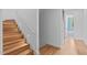 Wooden staircase with minimalist white walls and modern lighting, leading to the upper level at 501 S Bloodworth St # 101, Raleigh, NC 27601