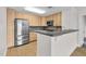 Kitchen with stainless steel fridge and microwave, wood cabinets, breakfast bar, and hardwood floors at 510 Glenwood Ave # 510, Raleigh, NC 27603