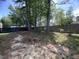 View of the backyard featuring a basketball hoop, mature trees, and a wood fence for added privacy at 5404 Drum Inlet Pl, Raleigh, NC 27610