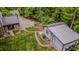 Aerial view of the property featuring an outbuilding, lush lawn, and mature trees at 5632 Falkirk Dr, Durham, NC 27712