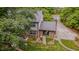 Aerial view of the brick home's rear exterior, manicured lawn, and lush surrounding landscape at 5632 Falkirk Dr, Durham, NC 27712