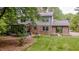 View of the backyard with brick exterior, screened-in porch, lush lawn, and mature trees at 5632 Falkirk Dr, Durham, NC 27712