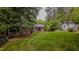 Expansive backyard with a brick home, outbuilding, and a lush green lawn surrounded by trees at 5632 Falkirk Dr, Durham, NC 27712