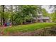 Lush backyard with a colorful playset, mature trees, and a brick home in a serene setting at 5632 Falkirk Dr, Durham, NC 27712