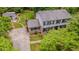 Aerial view of a two-story home with a long driveway, lush green yard, and a detached building at 5632 Falkirk Dr, Durham, NC 27712