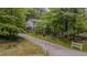 A two-story home with a long driveway, mature trees, and a well-manicured front lawn at 5632 Falkirk Dr, Durham, NC 27712