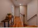 Hallway with hardwood floors, wood railing, and view to other rooms at 5632 Falkirk Dr, Durham, NC 27712
