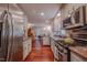 Spacious kitchen featuring stainless steel appliances, granite countertops, and warm wood flooring at 5632 Falkirk Dr, Durham, NC 27712