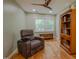 This room has hardwood floors, a ceiling fan, and a comfortable chair at 5632 Falkirk Dr, Durham, NC 27712