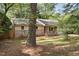 Cozy one-story home with brick accents, surrounded by mature trees and a lush front yard at 5805 Farm Gate Rd, Raleigh, NC 27606